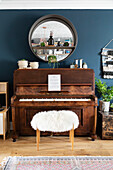 Vintage darkwood upright piano in living room of rustic scandi inspired home in Cardiff Wales UK