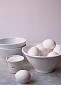 Still life in white of eggs bowls on marble worktop