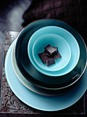 Stapel blauer und türkisfarbener Schalen und Teller auf einer Tischplatte