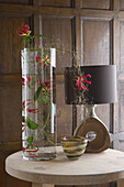 Table top display of fresh flowers lamp and vase in period wood panelled living room