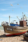 Seagulls fly above fishing boatd in Hastings Old Town England UK