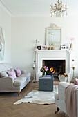 Lit fire and sofa with travelling chest in living room of Canterbury home England UK