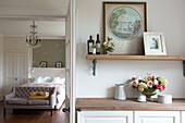 Wooden shelves in ensuite bathroom with view through doorway to bedroom of Canterbury home England UK