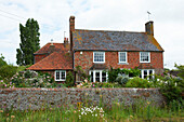 Brick wall and cottage garden exterior, Iden, Rye, East Sussex, UK