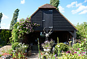 Creosote farm building in garden, Iden, Rye, East Sussex, UK
