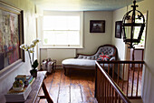 Chaise longue at window on landing in Iden farmhouse, Rye, East Sussex, UK