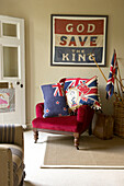 God Save the King' framed above red velvet armchair with Union Jack cushions in Suffolk home, England, UK