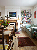 Bücherregal und Sofa im Esszimmer eines Hauses in Aldeburgh, Suffolk, England UK