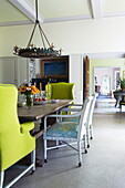Pair of yellow ing-back armchairs at dining table in Massachusetts home, New England, USA