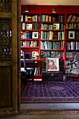 Red bookcase with patterned rug in Massachusetts home, New England, USA