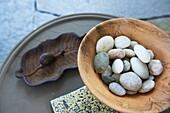 Pebbles in a wooden bowl with snail ornament in Massachusetts home, New England, USA