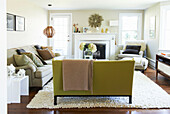 Beige blanket on lime green sofa with wooden pendant light in living room, the Berkshires, Massachusetts, Connecticut, USA