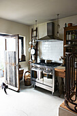 Stainless steel oven at open back door in Hastings home, East Sussex, England, UK