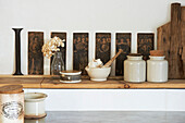 Keramikvorratsgefäße und Kunstwerke auf einem Holzregal in der Küche von Hastings, East Sussex, England, UK