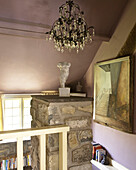 Chandelier with staircase artwork in staircase of Welsh cottage interior, UK