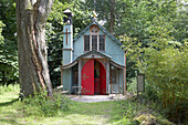 Patio terrace and painted exterior of chapel in remote woodland Shropshire, England, UK