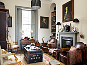 Drawing room with oil paintings matching chairs and a travelling trunk in city of Bath home Somerset, UK