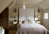 White fabric headboard on bed in Gloucestershire home, England, UK