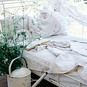 Vintage style daybed in garden summer house with floral linen