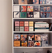 White storage shelving displaying order for CD and books