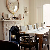 Contemporary country style dining room with large open fireplace and laid dining table