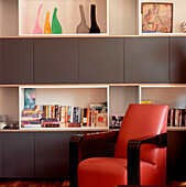Contemporary living room with storage open shelf unit and a red leather armchair