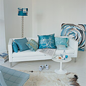 Contemporary coordinating living room with painted white floor boards white sofa and turquoise and white decor