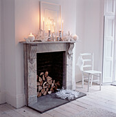 Fireplace with Christmas decorations and lit candles in a white contemporary living room