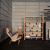 Wohnzimmer mit Wandpaneelen aus Beton, Retro-Stühlen und freistehendem Regal
