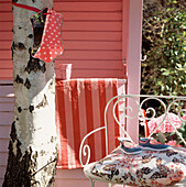 Pink painted garden summerhouse with garden furniture on a terrace 