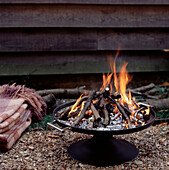 Portable campfire burning in a garden