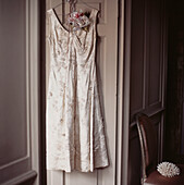Formelles weißes hübsches Kleid einer Frau hängt an einer Tür