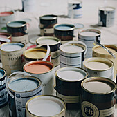 Lots of paint pots with the lids off displaying colours