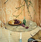 Still life of rustic vintage metal table and chairs with tableware