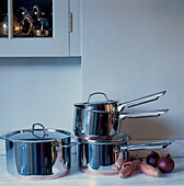 Stainless steel kitchen pots and saucepans on a worktop