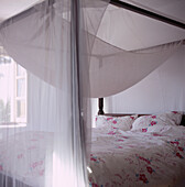 Four poster bed draped in voile