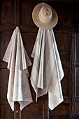 Fabric samples and straw hat hang in panelled room, UK