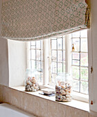 Storage jars with seashells on windowsill of UK home