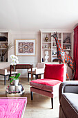 Red velvet chair with large giraffe statue in living room in contemporary London home England UK