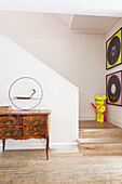 Antique sideboard in wooden staircase hallway of contemporary London home England UK