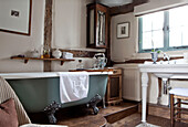 Freestanding claw-foot bath in split-level timber framed bathroom in old Ripley home West Yorkshire England UK