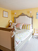 Up-cycled singe bed in yellow room of old Ripley home West Yorkshire England UK