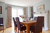 Brown chairs at table in light blue dining room of contemporary Chelsea home London UK