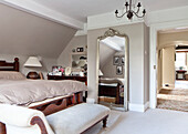 Durchgehender Silberspiegel und Chaiselongue im Schlafzimmer eines Hauses in Surrey, England UK