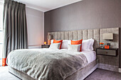 Komfortables Doppelzimmer in sanftem Grau mit leuchtend orangefarbenen Details