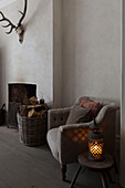 Lit candle and upholstered chair at fireside in Hove living room East Sussex England UK