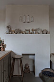 Assorted ceramics with bar stool and coal bucket in Hove kitchen East Sussex England UK