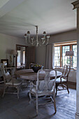 Antique wooden dining chairs at circular wooden table in Guildford farmhouse Surrey England UK