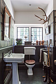 Pedestal basin and cistern in Arts and Crafts style washroom of Haslemere home, Surrey, UK