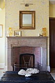 Gilt framed mirror above exposed brick fireplace in Haslemere home, Surrey, UK